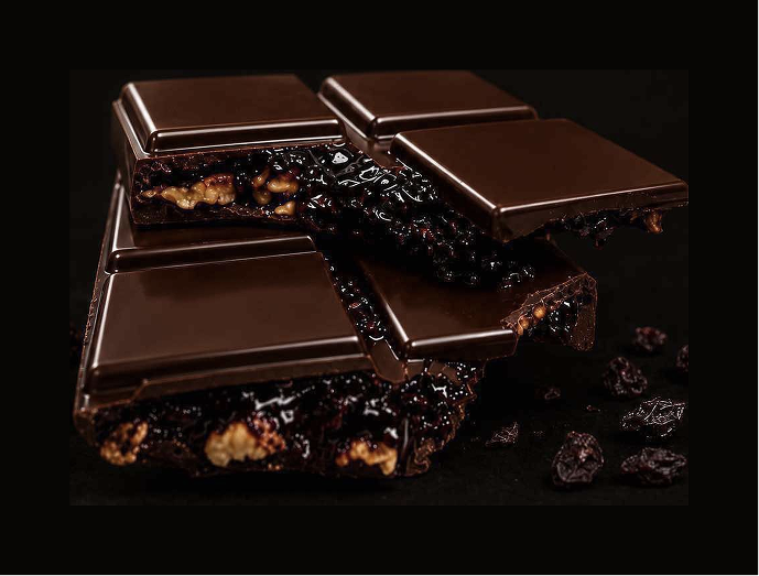 Broken bars of HaskaNoir dark chocolate showing the walnut and Haskap berry filling